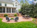 Inviting brick patio with comfortable seating area, fire pit, and a view of the landscaped yard at 1176 Fawn Ridge Nw Rd, Concord, NC 28027