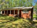 Charming brick ranch with a covered front porch and a well-manicured lawn at 1199 Riding Trail Ln, Concord, NC 28027