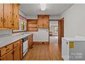 Traditional kitchen with wooden cabinets, laminate counters, and light hardwood floors at 1315 Arbor Dr, Salisbury, NC 28144
