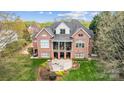 Stunning backyard featuring a patio with fireplace, balcony, and pristine landscaping at 1404 Churchill Downs Dr, Waxhaw, NC 28173