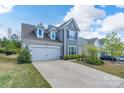 Traditional two-story home with a two-car garage, landscaped front yard, and classic architectural design at 16803 Cozy Cove Rd, Charlotte, NC 28278