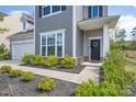 Inviting front entrance featuring a well-maintained walkway, a decorative wreath, and attractive landscaping at 16803 Cozy Cove Rd, Charlotte, NC 28278