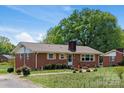 Side view of a quaint brick home with a chimney and mature trees providing shade at 175 Neita Dr, Salisbury, NC 28147