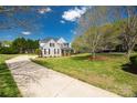 Beautiful home with a long driveway, stone accents, black shutters, a front porch, and a lush green lawn at 2004 Ptarmigan Ct, Waxhaw, NC 28173