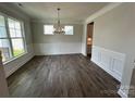 An elegant dining room featuring wood floors, decorative molding, and a stylish chandelier at 2017 Embassy Ct # 51, Charlotte, NC 28213