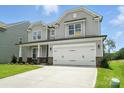 Charming two-story home featuring a gray exterior, manicured lawn, and a two-car garage at 2017 Embassy Ct # 51, Charlotte, NC 28213