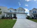 Charming two-story home with gray siding, a well-manicured lawn, and attached two-car garage at 2017 Embassy Ct # 51, Charlotte, NC 28213