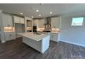 Modern kitchen features white cabinets, a marble backsplash, stainless steel appliances, and an island at 2017 Embassy Ct # 51, Charlotte, NC 28213