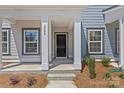 Inviting front porch with a black front door, white columns and the house number prominently displayed at 4004 Crooked Spruce Ct, Matthews, NC 28105