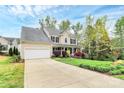 Two-story home featuring an attached garage and beautifully landscaped front yard with a long, wide driveway at 4086 Buckingham Dr, Fort Mill, SC 29707