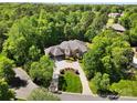 Aerial view of a stately brick home with a circular driveway, attached garage, and lush landscaping at 5001 Oxfordshire Rd, Waxhaw, NC 28173
