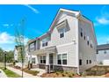 Well-maintained townhome with a charming front porch, stone accents, and fresh landscaping under a bright sky at 5850 Strathmore Ct, Charlotte, NC 28215