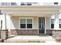 Inviting front porch with stone-clad pillars and black door creating a welcoming entrance to the home at 5850 Strathmore Ct, Charlotte, NC 28215