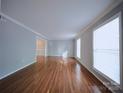 Large living room features hardwood floors and natural light from two large windows at 6430 Farmingdale Dr, Charlotte, NC 28212
