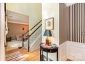 Inviting foyer with hardwood floors, a staircase with white railings, and decorative wall art and furnishings at 6615 Wickville Dr, Charlotte, NC 28215