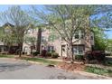 Charming brick townhomes boast lush landscaping and well-maintained exteriors under a sunny sky at 729 Naramore St, Davidson, NC 28036