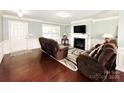 Inviting living room featuring hardwood floors, a fireplace, and comfortable seating at 7928 Ponderosa Pine Ln, Charlotte, NC 28215