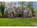Stunning brick home featuring a well-maintained lawn and a covered front porch at 8209 Bella Vista Ct, Charlotte, NC 28216
