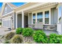 Cozy front porch with a comfortable chair and beautifully landscaped surroundings at 8718 Festival Way, Charlotte, NC 28215