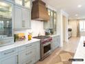 Gourmet kitchen with custom cabinets, marble countertops, stainless steel appliances, and a decorative range hood at 8805 Wingard Dr, Waxhaw, NC 28173