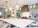 Open kitchen with a large island, marble countertops, stylish lighting fixtures, and stainless steel appliances at 8805 Wingard Dr, Waxhaw, NC 28173