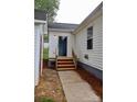 Rear exterior entrance featuring wood steps and a concrete path, with a door that has glass from top to bottom at 904 Brook St, Belmont, NC 28012