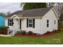 Attractive single-story home showcasing a well-maintained lawn, updated windows, and crisp, clean white siding and black shutters at 904 Brook St, Belmont, NC 28012