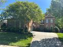 Beautiful brick home with lush green lawn and mature trees providing shade at 1024 Westbury Dr, Matthews, NC 28104
