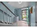Light and airy foyer with light blue walls, wood floors, and staircase at 10308 Garrett Grigg Rd, Charlotte, NC 28262