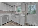 Close up of the bright kitchen with stainless steel dishwasher, sink, and marble countertop at 132 Riverview Acres Ln, Taylorsville, NC 28681