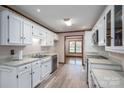 Traditional style kitchen with white cabinets, stainless steel appliances, light counters, and wood-look flooring at 1478 Smith Farm Rd, Lincolnton, NC 28092