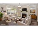 Inviting living room with a cozy fireplace, large windows, and stylish furnishings at 14917 Dewpoint Pl, Huntersville, NC 28078