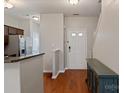 Hallway view featuring wood floors, a white front door, staircase, and a storage cabinet at 1518 Sylvia Ct, Charlotte, NC 28205