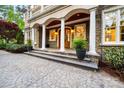 Elegant stone front entrance with stately columns, a wood door, and manicured landscaping at 210 Dexter Ave, Kannapolis, NC 28081