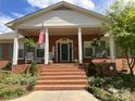 Inviting front porch with American flag, rocking chairs, and hanging plants, creating a welcoming entrance at 217 Windsor Dr, Shelby, NC 28150