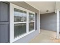 Inviting entryway featuring a glass-paneled front door and sleek gray siding, providing a welcoming first impression at 224 Old Harbor Dr, Mount Gilead, NC 27306