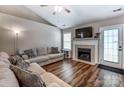Comfortable living room featuring a fireplace, vaulted ceiling, modern flooring, and a cozy seating arrangement at 239 Bradford Glyn Dr, Mooresville, NC 28115