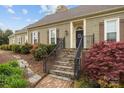Home's front entrance with brick stairs, beautiful landscaping, and dark shutters provide curb appeal at 405 Downing Dr, Kings Mountain, NC 28086