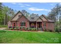 Charming brick home with red accents, a cozy front porch, and a well-manicured lawn at 4637 Gold Finch Dr, Denver, NC 28037