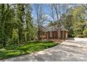 A brick home with a long driveway surrounded by lush greenery and trees on a sunny day at 481 Patriot Ne Ct, Concord, NC 28025