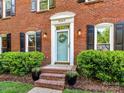 Charming front entrance features a light blue door, potted plants, and brick steps at 5043 Hickory Lake Ln, Matthews, NC 28105