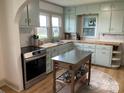 Charming kitchen featuring blue cabinets, butcher block countertops, stainless steel appliances, and an island at 5373 Nc Hwy 16 N Hwy, Taylorsville, NC 28681