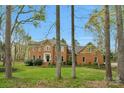 Beautiful brick two-story home with lush green lawn and mature trees, creating a serene setting at 5750 Hemby Rd, Matthews, NC 28104