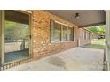 Covered porch area featuring brick exterior, a screen door, and a white railing to provide a secure space at 600 Community Ln, Lancaster, SC 29720
