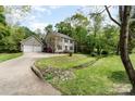 View of the exterior featuring an attached two-car garage, driveway, manicured lawn and mature landscaping at 608 Grace St, Shelby, NC 28150