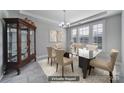 Formally staged dining room showcasing elegant glass table, neutral chairs, and a vintage china cabinet at 610 Blaise Ct, Matthews, NC 28104