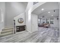 Bright foyer featuring a staircase, wood-look flooring, and a decorative mirror above a wooden console table at 610 Blaise Ct, Matthews, NC 28104