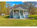 A quaint home with a covered porch and landscaped front yard at 612 Rowan Mill Rd, Salisbury, NC 28147