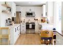 Bright kitchen with white cabinets, stainless steel appliances, and wood-look flooring at 6718 Rollingridge Dr, Charlotte, NC 28211