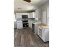 Modern kitchen featuring new stainless steel appliances, white cabinets, and durable vinyl flooring at 736 Lawndale Cir, Fort Lawn, SC 29714